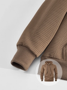 Detailed macro view of coffee brown knit hoodie featuring premium herringbone texture and ribbed cuffs