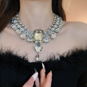 Statement luxury necklace with heart and drop crystals on silver base worn by a model