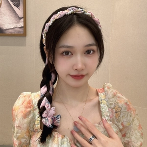 Detail showing pink floral fabric headband with white pearls worn by a fashion model