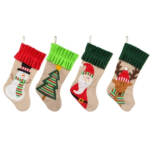 Set of four burlap Christmas stockings featuring Santa, reindeer, snowman, and tree designs
