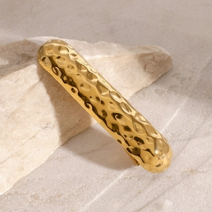 Haarklammer aus Edelstahl in Gold mit Hammerschlag-Textur auf modernem Stein-Hintergrund