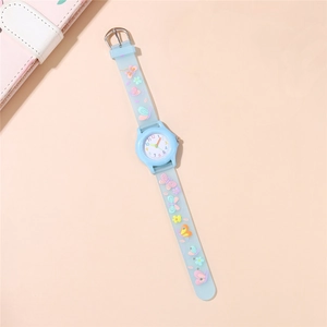 Macro detail of kids watch with light blue butterfly embossed silicone strap and round dial