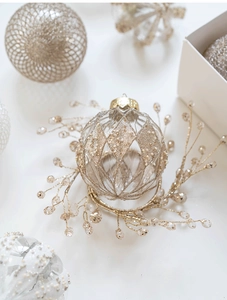 Détail d'une boule de Noël 8cm blanc et or avec motif pailleté et support perlé