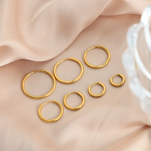 Set of seven graded gold-plated titanium steel hoop earrings on champagne silk fabric