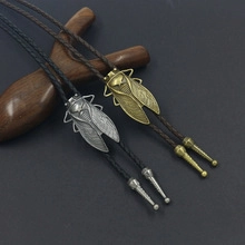 Detail of silver and bronze cicada bolo ties with braided leather cords and metal tips