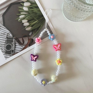Detail of beaded phone strap with pink tulips and colorful acrylic flower charms