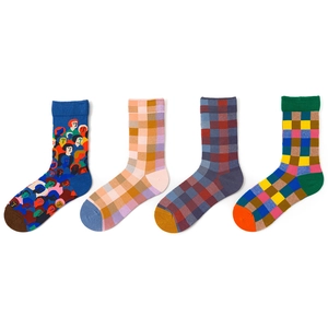 Close-up of four colorful cotton socks with abstract face and geometric patterns