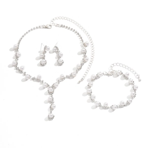 Elegant pearl and rhinestone jewelry set with necklace earrings and bracelet on white