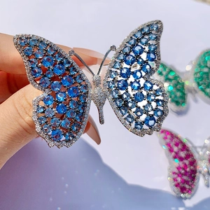 Macro shot of silver butterfly brooch with blue zircon inlay and intricate filigree work