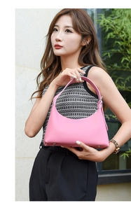 Detailed view of pink crescent shoulder bag with smooth leather finish and base rivets