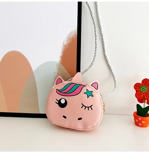 Macro detail of pink unicorn purse with silver braided strap and cartoon design