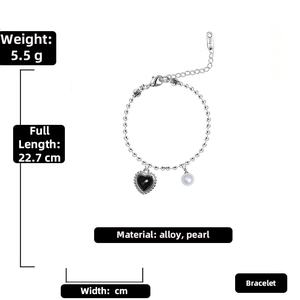 Detailed view of silver alloy bracelet with black heart pendant and white pearl