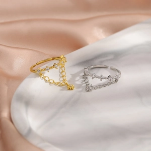 Detail of gold and silver double-layer rings with star charms on marble and satin