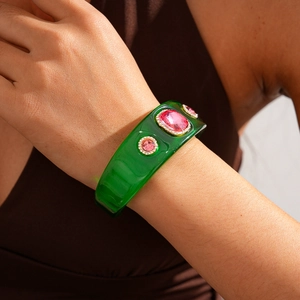Detail of vintage green resin bangle with pink rhinestones on a wrist