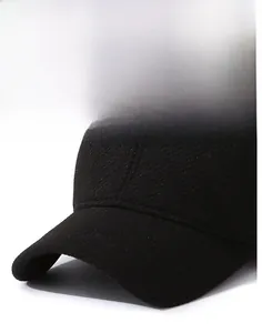 Close-up of a black winter baseball cap with textured wool fabric and metal logo detail
