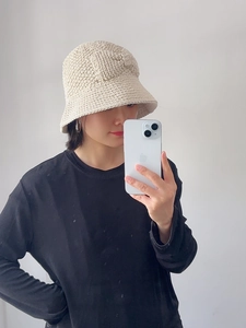Détail d'un chapeau cloche en coton beige crocheté à la main avec texture tricotée