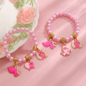 Détail de bracelets en perles roses avec breloques ruban rose et accents de cœur doré