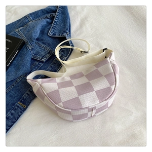 Purple and white checkered fanny pack with adjustable strap on white bedding backdrop