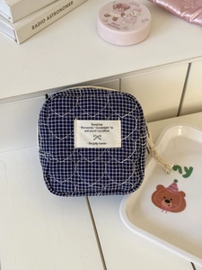 Macro detail of dark blue checkered cotton fabric with heart quilting and fabric label
