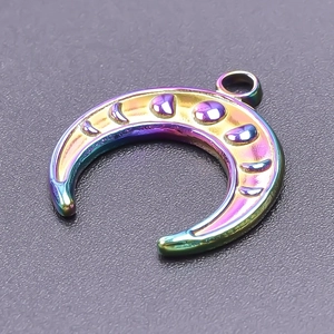 Macro shot of iridescent rainbow finish crescent moon pendant with detailed engravings