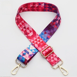 Detail of colorful geometric woven shoulder strap with gold-tone metal lobster clasps