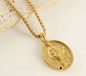 Macro detail of 18k gold plated 3D oval saint pendant with polished embossed finish