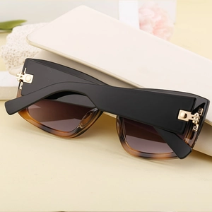 Detail of cat eye sunglasses with golden hinges and brown gradient lenses