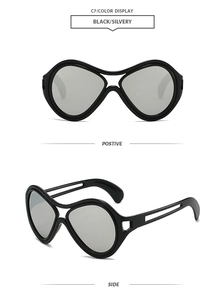 Detail view of oversized black sunglasses with hollowed temples and silver mirrored lenses