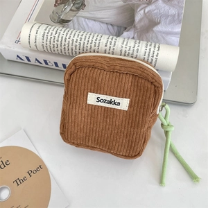 Detail view of a mini brown corduroy organizer bag with zipper and green pull cord