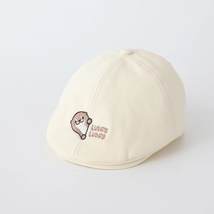 Détail de la broderie loutre et texte Lutra sur le béret en coton crème pour bébé