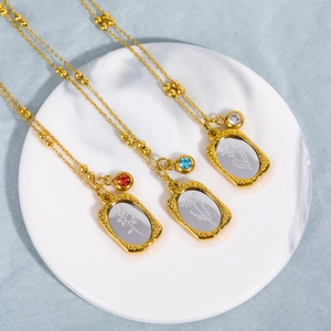 Detailed view of gold rectangle pendants with floral engravings and colorful zircon gems