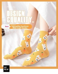 Detail of yellow cotton socks featuring white rabbit and carrot patterns in cute style