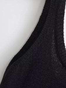 Gros plan sur la texture en tricot noir et détails des bretelles d'une robe ajustée