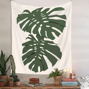Detail eines Wandteppichs mit Monstera-Blättern über einem Holztisch mit vielen grünen Pflanzen