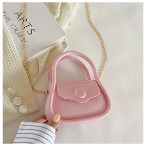 Pink jelly handbag detail with gold chain strap on stylish lifestyle background