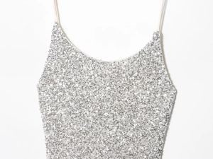 Gros plan détaillé des paillettes argentées sur une robe de soirée à bretelles