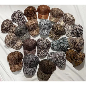 Flat lay display of various leopard print baseball caps in multiple colors and patterns