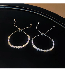Detail showing adjustable gold and silver tennis bracelets with glittering crystals