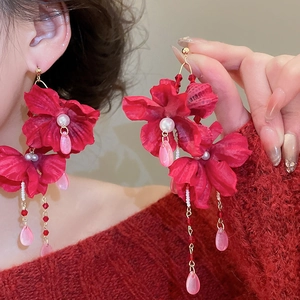 Detail of red fabric flower earrings with crystal tassels and white pearl centers
