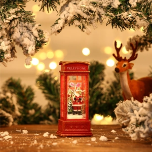 Close-up of red Christmas telephone booth lamp with Santa Claus and festive snow scene