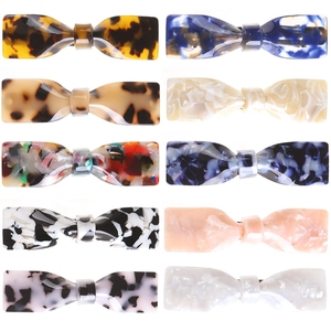 Flat bow-shaped acetate hair claws set in various marble and tortoiseshell patterns