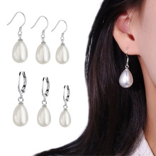 Detail of silver teardrop pearl earrings showing hook style and on-ear look