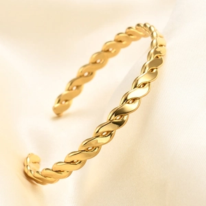 Elegant 6mm gold C-shaped twisted rope cuff bracelet on white silk background
