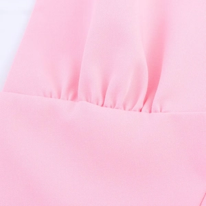 Makroaufnahme des rosa Midikleides mit Twill-Stoffstruktur und plissierten Details