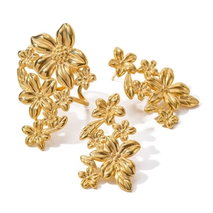 Golden floral jewelry set with ring and earrings on a clean white background