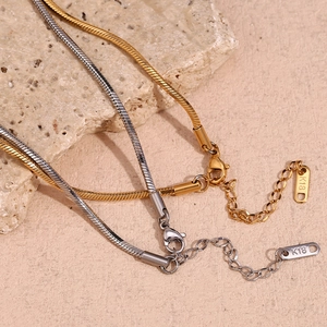 Detail of 18K gold and silver snake chain necklaces with lobster clasp and K18 tag
