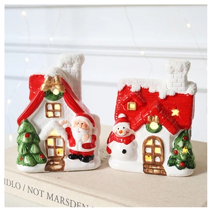 Detail view of glowing ceramic Christmas snow house ornaments with warm LED light