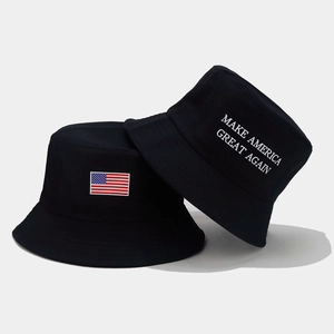 Détail de bobs en coton noir avec écusson drapeau américain et slogan politique brodé