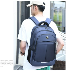 Rear view of deep blue nylon laptop backpack with multi-layer zippers and side mesh pocket