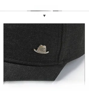 Detail of black cotton baseball cap showing decorative RZG metal buckle and fabric texture